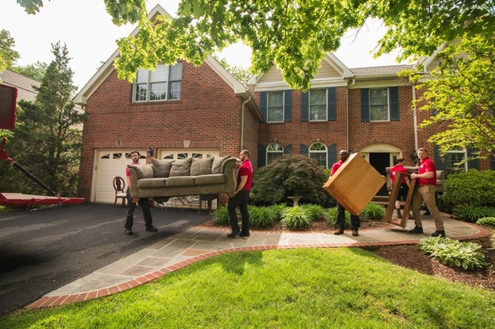 several men moving furniture outside a house