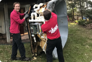 Two professionals from 123Junk, wearing branded uniforms and protective gear, efficiently removing a hot tub from a residential backyard. They carefully disassemble the hot tub, haul away the pieces using specialized equipment, and ensure the area is left clean and tidy after the removal process.