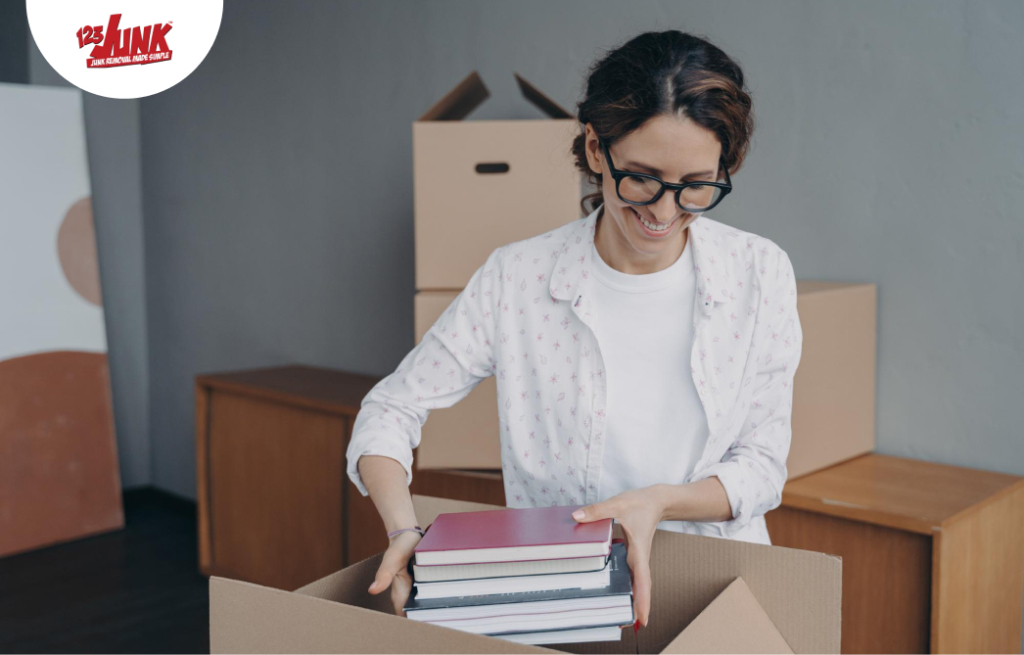 Young european woman packing container and puts textbooks into Relocation and entering to college